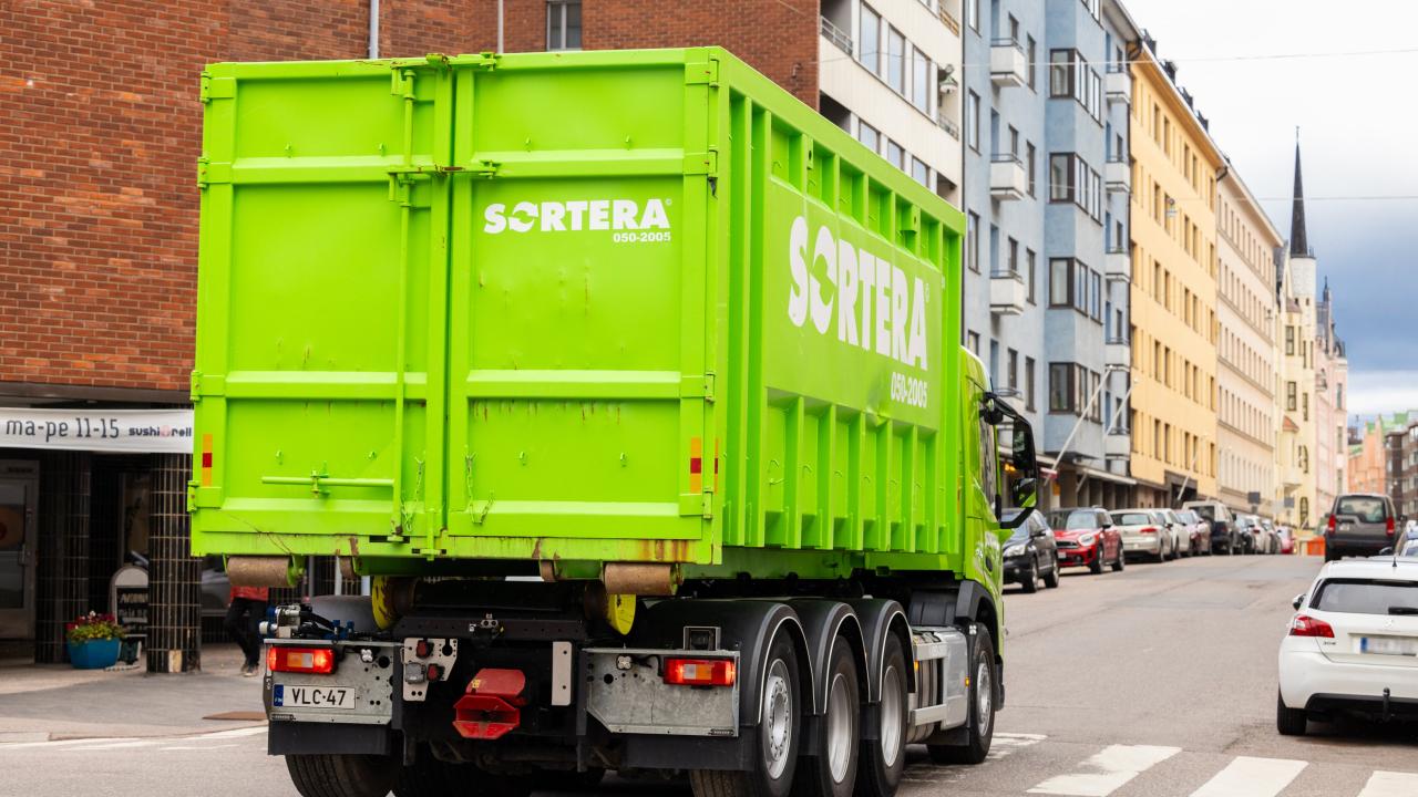 Sortera kuorma-auto vihreän vaihtolavan kanssa Helsingissä