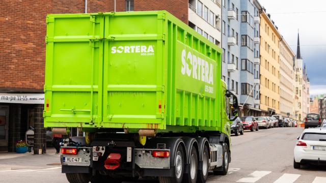 Sortera kuorma-auto vihreän vaihtolavan kanssa Helsingissä